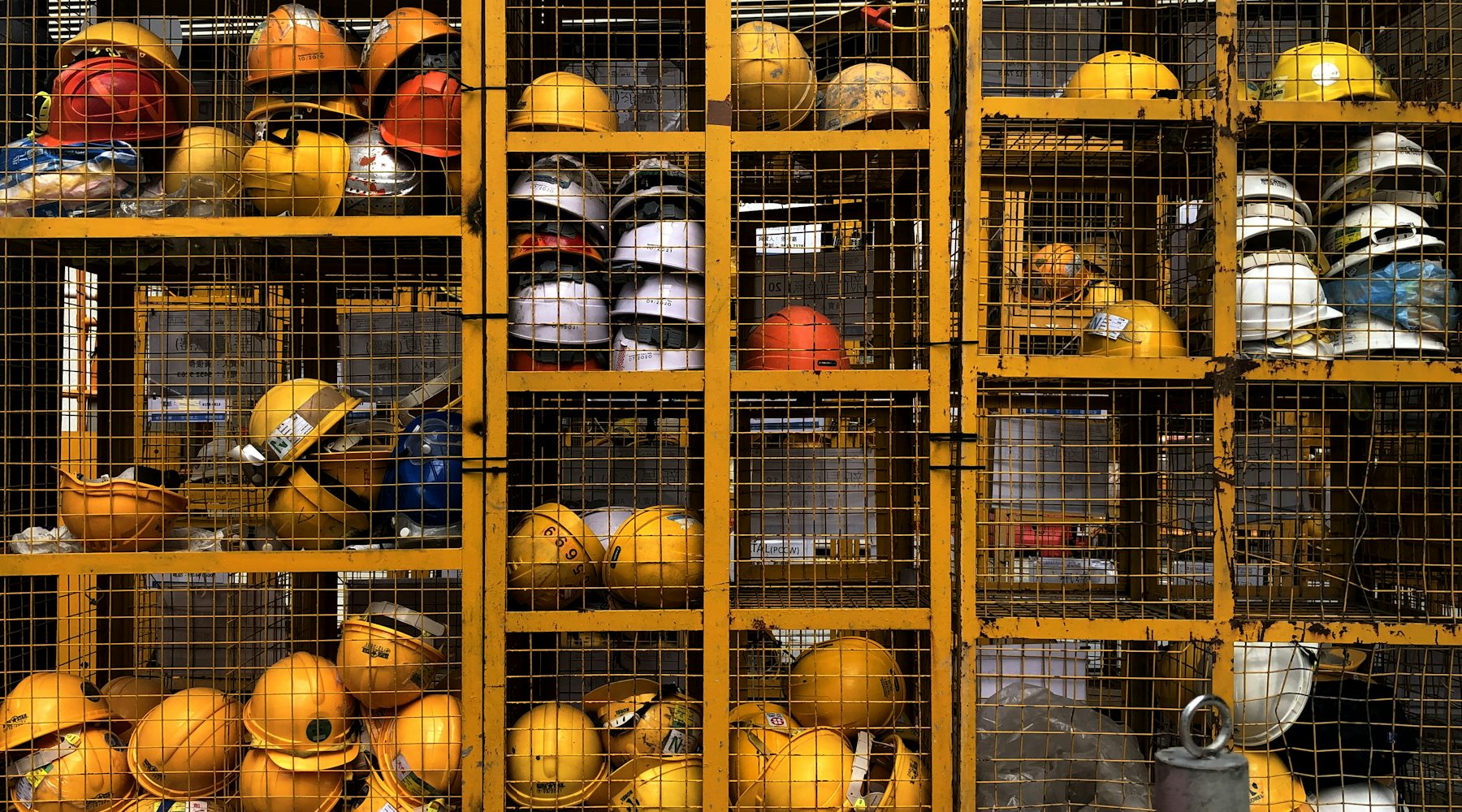 Rows of yellow safety helmets stored in racks at an industrial site