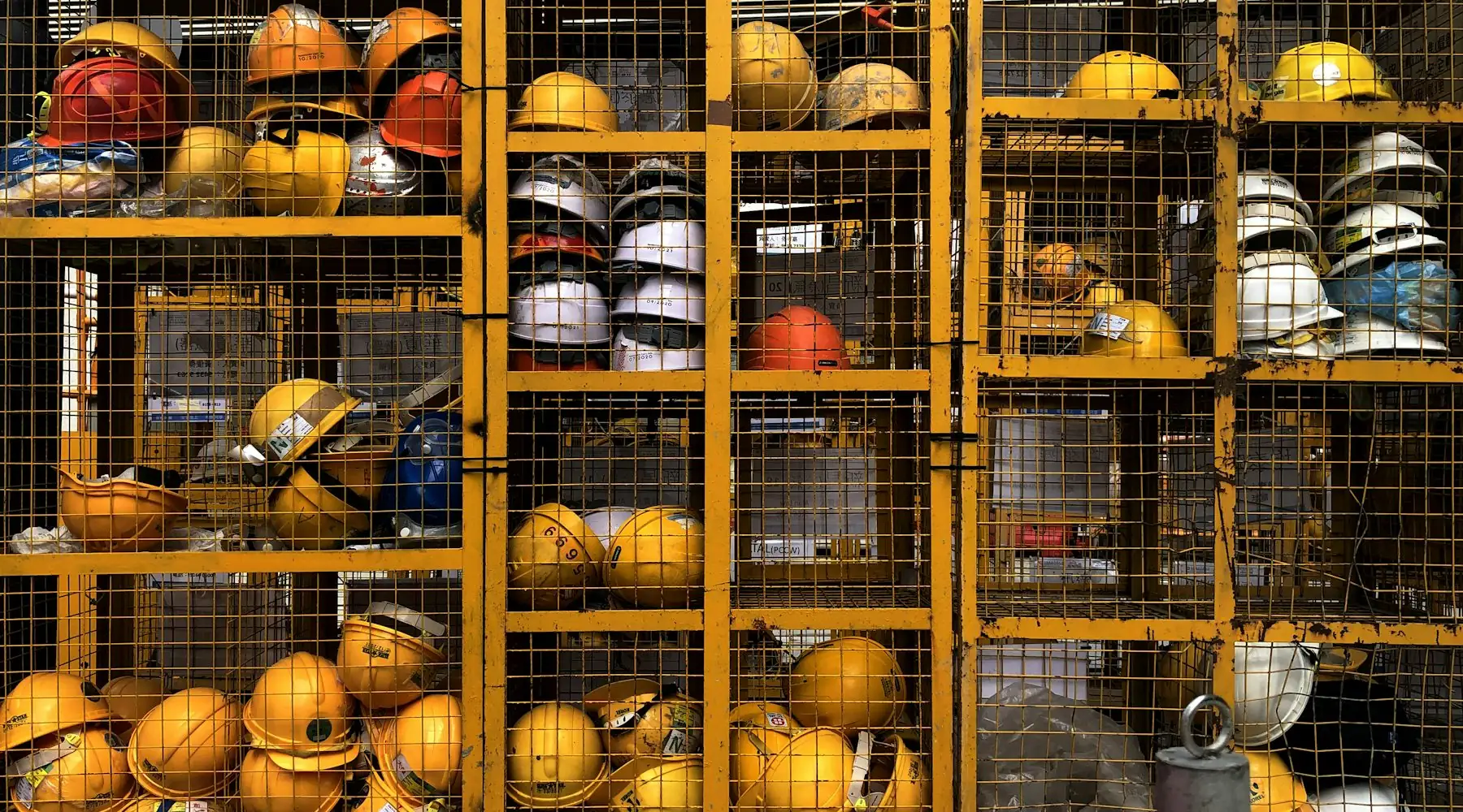 Rows of yellow safety helmets stored in racks at an industrial site