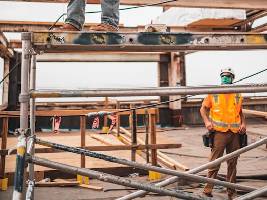 Site worker in a safety helmet, high visibility vest and face mask